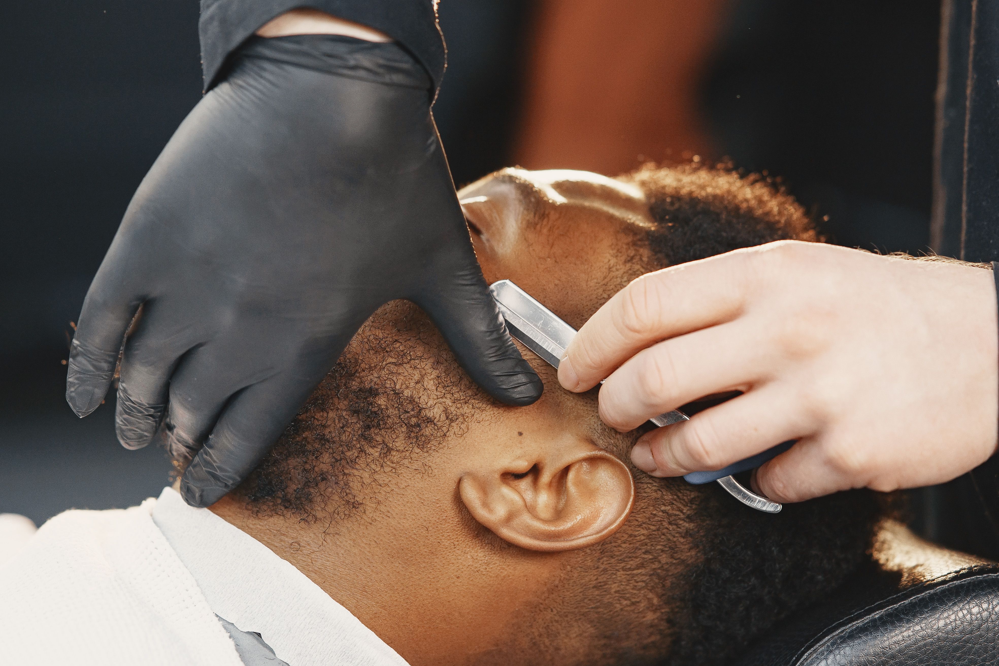 Barber-Detailaufnahme: Eine Bartkontur wird mit einem Rasiermesser bearbeitet